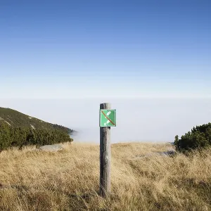 No entry warning sign on a meadow at precipice on mountain peak