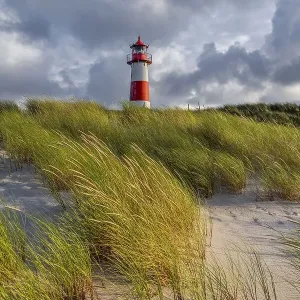 Evening light, red-white lighthouse List-East in the dunes