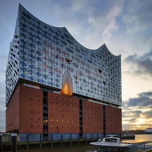Excursion boat in front of the glass facade of the Elbe Philharmonic Hall