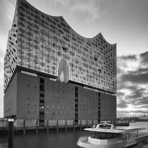 Excursion boat in front of the glass facade of the Elbe Philharmonic Hall