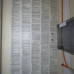 An extensive poster with regulations for the operation of electrical systems is attached to a wall
