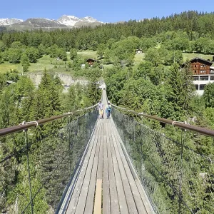 Extensive suspension bridge in idyllic mountain and forest areas in sunny weather