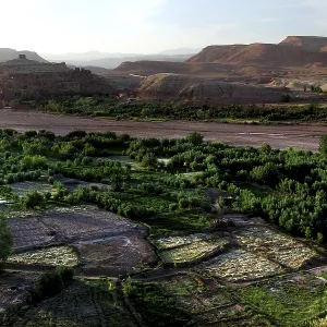 Extensive valley with green meadows and a river in the distance