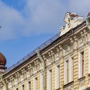 Facade of a historic building with decorated reliefs and dome under a blue sky