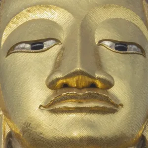 Face of a 32 metre high standing Buddha decorated with glass mosaics and 24-carat gold