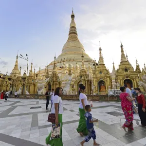 Family walking in front of a large golden pagoda in the evening