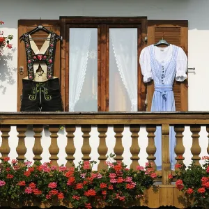 Farmhouse with lederhosen and a dirndl hanging on the shutters