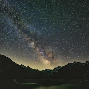 Fascinating Milky Way over a dark mountain panorama