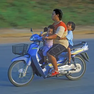 Father with his two children on a moped Father with his two children on a moped