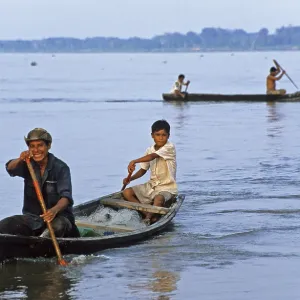 Father and son in a paddle boat on the Amazon near Iquitos Father and son in a paddle boat on the Amazon near Iquitos