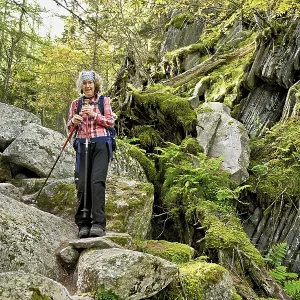 Female hiker on mountain tour standing in rocky terrain Female hiker on mountain tour standing in rocky terrain