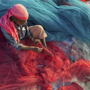 Fisherman repairing fishing nets Fisherman repairing fishing nets