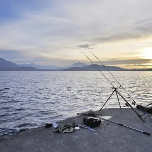 Two fishing rods on a tripod with many accessories set up on Lake Zug