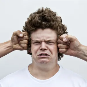 Two fists attacking the head of a young man