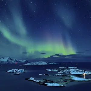 Fjord with islands in winter and the northern lights