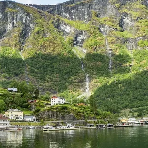 Flam village nestled beneath towering mountains on the Norwegian fjord Flam village nestled beneath towering mountains on the Norwegian fjord