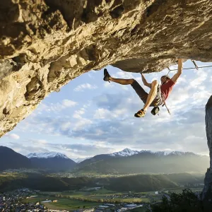 Freeclimber with helmet climbing on a rock face