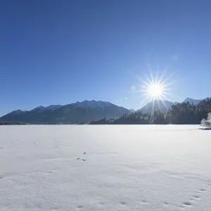 Frozen lake Barmsee with Karwendel mountainrange on morning with sun in winter Frozen lake Barmsee with Karwendel mountainrange on morning with sun in winter