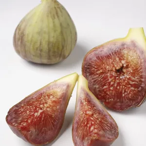 Fruit, one full Fig Ficus Carica Anjir and another cut in three pieces on white background