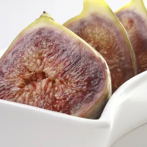 Fruit, Figs Ficus Carica Anjir two cut in four halve kept ins shape white plate on white background