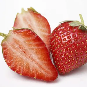 Fruit, Strawberry Fragaria Ananassa one full and two half on white background