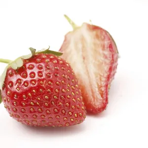 Fruit, Strawberry Fragaria Ananassa one full and one half on white background