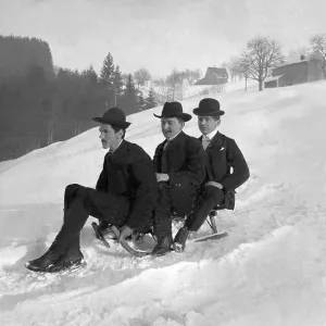 Three gentlemen riding a sled, historical image