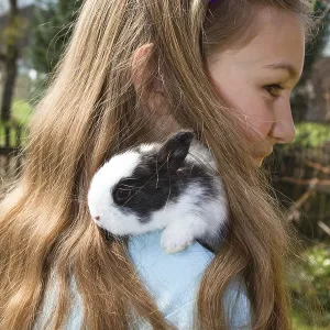 Fille, 10 ans, avec un lapin de compagnie.