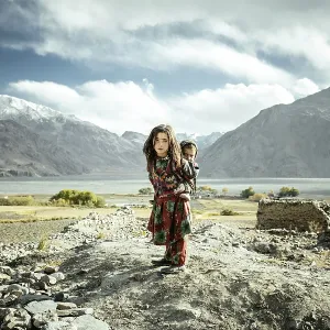 Girl carrying her little brother on her back