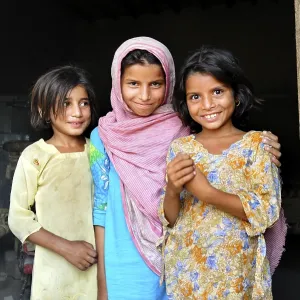 Three girls in the entrance of a simple house Three girls in the entrance of a simple house