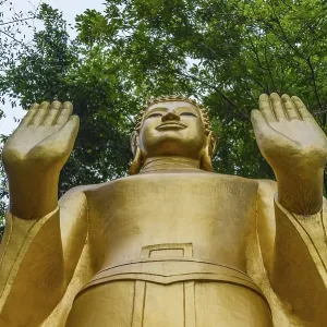 Golden Buddha statue with raised hands Golden Buddha statue with raised hands