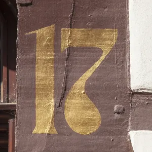 Golden house number plate number seventeen on a half-timbered house in the old town centre Golden house number plate number seventeen on a half-timbered house in the old town centre