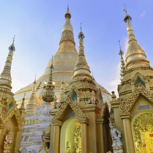 Golden pagoda and towers in evening light against a clear sky