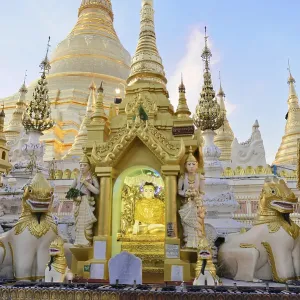 Golden sculptures and carved figures in front of a pagoda
