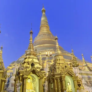 Golden stupas shining in evening light against deep blue sky