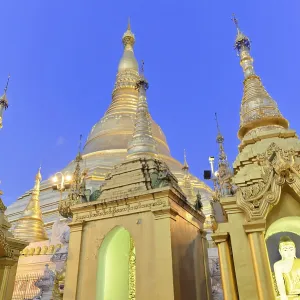 Golden stupas of a temple at dusk on a clear evening