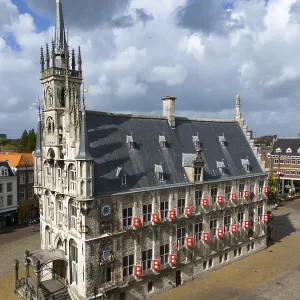 Gothic town hall in a city centre with characteristic architecture and cloudy sky