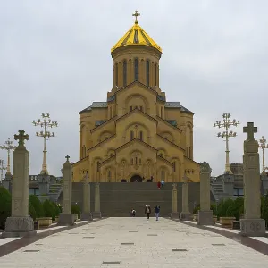 Grand cathedral with golden roof and stylish stone pillars against cloudy sky Grand cathedral with golden roof and stylish stone pillars against cloudy sky