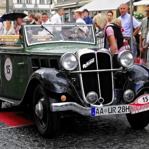 Coche clásico convertible verde en un entorno urbano durante un evento con personas y llovizna ligera, 2000 km a través de Alemania en 2009. Coche clásico convertible verde en un entorno urbano durante un evento con personas y llovizna ligera, 2000 km a través de Alemania en 2009.