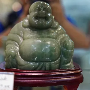 Green jade figure of a laughing Buddha on a pedestal Green jade figure of a laughing Buddha on a pedestal