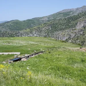Green meadows and hills with mountains in the background on a sunny spring day Green meadows and hills with mountains in the background on a sunny spring day
