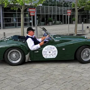 Green roadster with driver at a stylish classic car event on the road