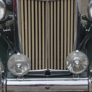 Green vintage car with striking vertical radiator grille and round headlights