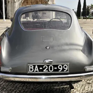 Grey vintage car parked from behind in a square