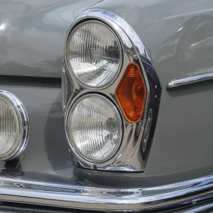 Grey vintage car with striking headlights and chrome details