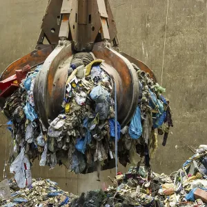 Gripper arm over pile of trash