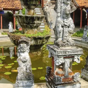 Guardian figures in front of an old well in Brahma Vihara Arama Buddha Banjar Buddhist monastery Guardian figures in front of an old well in Brahma Vihara Arama Buddha Banjar Buddhist monastery