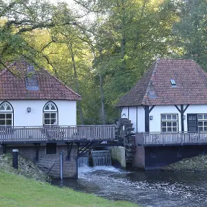 Two half-timbered houses on a river with a mill surrounded by trees and nature Two half-timbered houses on a river with a mill surrounded by trees and nature