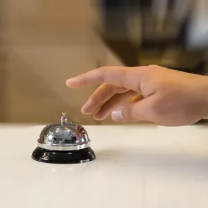 Hand of a man using a retro hotel bell Hand of a man using a retro hotel bell