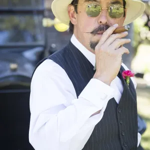 Handsome 1920s dressed man near vintage car smoking A cigar Handsome 1920s dressed man near vintage car smoking A cigar
